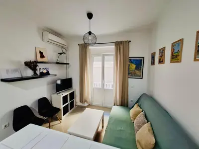 a living room with a green couch and a window at Apartamento Feduchy in Cádiz