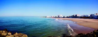 a view of a beach with buildings in the background at 7Escalones in Rota