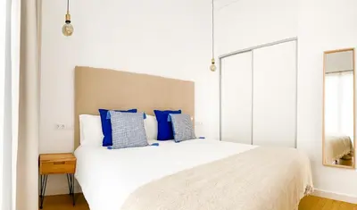a bedroom with a large white bed with blue pillows at 7Escalones in Rota