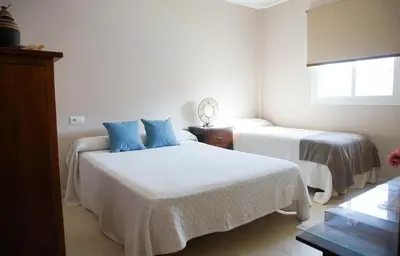 a bedroom with two beds and a window at Casa/Chalet Doñana in Sanlúcar de Barrameda