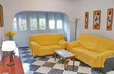 a living room with two yellow chairs and a table at Apartamento Plaza la Fuente in Cádiz