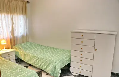 a bedroom with two twin beds and a dresser at Apartamento Plaza la Fuente in Cádiz