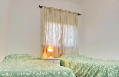 a bedroom with two twin beds and a window at Apartamento Plaza la Fuente in Cádiz