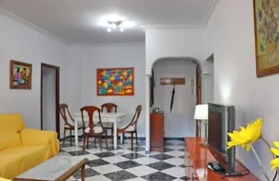 a living room with a yellow couch and a table at Apartamento Plaza la Fuente in Cádiz