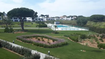 a garden with flowers and a swimming pool at Vivienda Vistahermosa Playa in El Puerto de Santa María