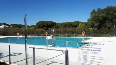 a swimming pool with a sign in front of it at Vivienda Vistahermosa Playa in El Puerto de Santa María