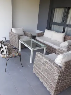 a living room with wicker chairs and a glass table at Vivienda Vistahermosa Playa in El Puerto de Santa María