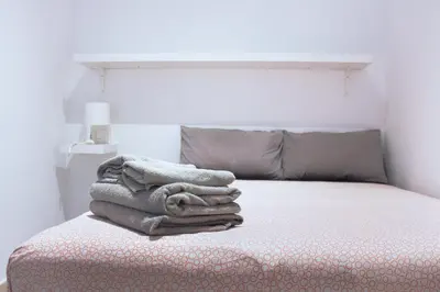 a pile of towels sitting on top of a bed at Campo del Sur - Catedral in Cádiz