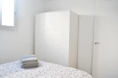 a white bedroom with a bed and a closet at Campo del Sur - Catedral in Cádiz