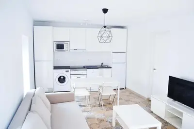 a white living room with a couch and a table at Campo del Sur - Catedral in Cádiz