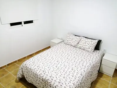 a white bedroom with a bed and two pillows at Campo del Sur - Catedral in Cádiz