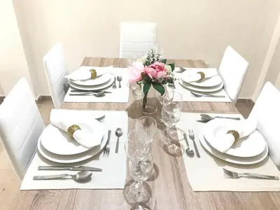 a dining room table with white plates and silverware at Apartamento !!VIVE JEREZ!! in Jerez de la Frontera