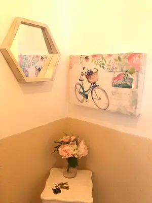 a vase of flowers on a shelf with a bike on the wall at Apartamento !!VIVE JEREZ!! in Jerez de la Frontera
