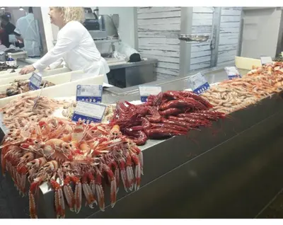 a woman standing in front of a display of seafood at Playa caleta 7 min, wifi, catedral, centro in Cádiz