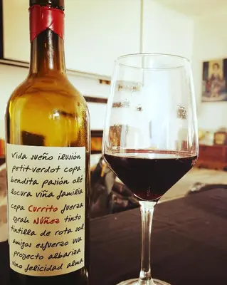 a bottle of wine sitting next to a glass at LA BENDITA LOCURA in El Puerto de Santa María