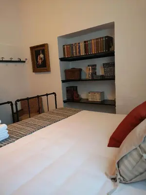 a bedroom with a bed and a book shelf with books at LA BENDITA LOCURA in El Puerto de Santa María