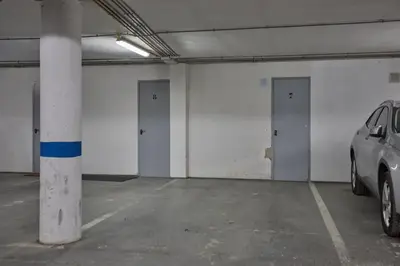 a parking garage with three doors and a car in it at corazón de jerez edificio de 1861 in Jerez de la Frontera
