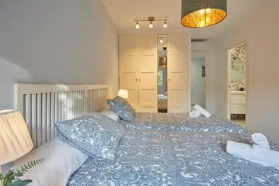 a bedroom with a large bed with blue sheets and pillows at corazón de jerez edificio de 1861 in Jerez de la Frontera
