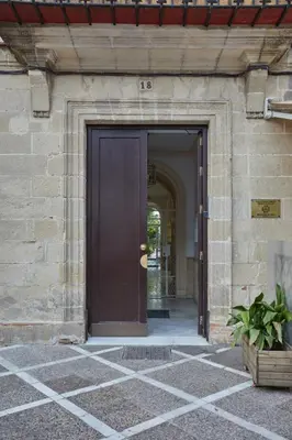 a brown door in a stone building at corazón de jerez edificio de 1861 in Jerez de la Frontera