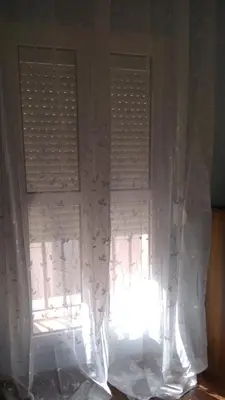 a window with white curtains in a room at Apartamento Entre el Falla y la Caleta in Cádiz