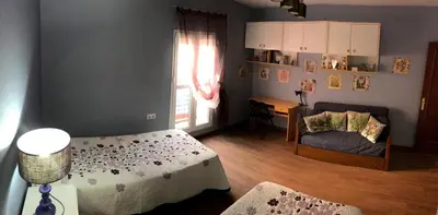 a bedroom with two beds and a table and a window at Apartamento Entre el Falla y la Caleta in Cádiz