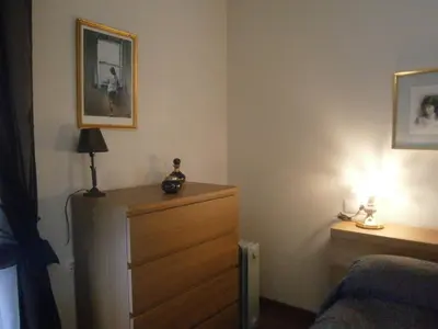 a bedroom with a dresser and a lamp and a bed at Apartamento Entre el Falla y la Caleta in Cádiz