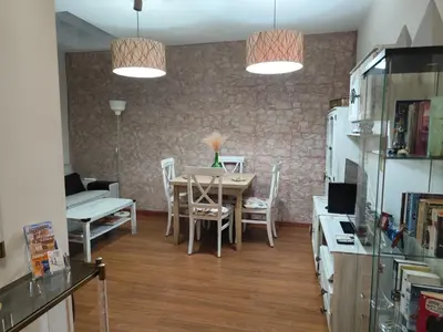 a living room with a table and chairs and two lights at Apartamento Entre el Falla y la Caleta in Cádiz