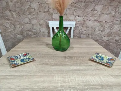 a green vase sitting on a table with two cards at Apartamento Entre el Falla y la Caleta in Cádiz