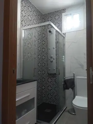a bathroom with a glass shower with a toilet at Apartamento La Domus in Cádiz