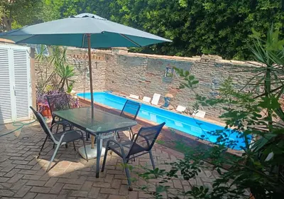 a table and chairs with an umbrella next to a pool at Apartamento La Domus in Cádiz