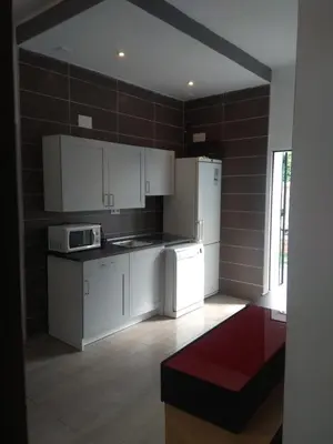 a kitchen with white cabinets and a white refrigerator at Apartamento La Domus in Cádiz