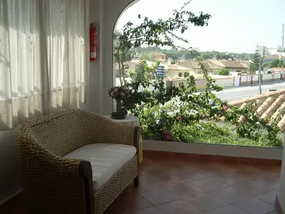 a room with a chair and a window with a view at Hotel Cortijo Los Gallos in Chiclana de la Frontera
