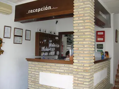 a woman sitting at the counter of a restaurant at Hotel Cortijo Los Gallos in Chiclana de la Frontera