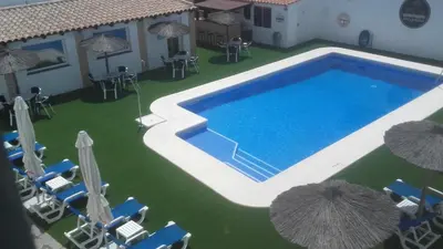 an overhead view of a swimming pool with chairs and umbrellas at Hotel Cortijo Los Gallos in Chiclana de la Frontera