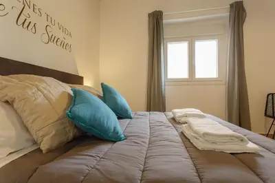 a large bed with blue pillows in a bedroom at Balcones de CANDELARIA by Cadiz4Rentals in Cádiz