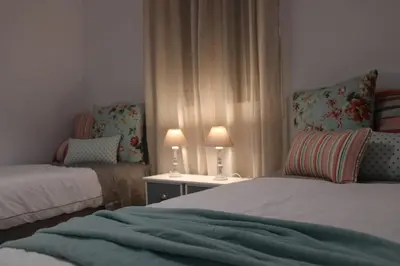 a bedroom with two beds and a table with two lamps at SHERRY HOME in Jerez de la Frontera