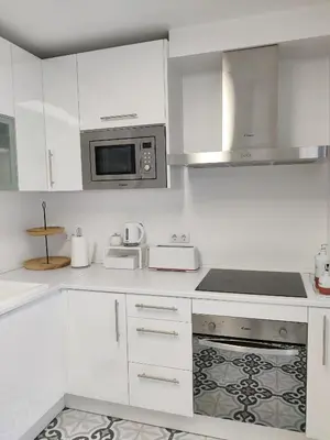 a kitchen with white cabinets and a microwave at SHERRY HOME in Jerez de la Frontera