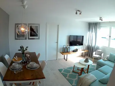 a living room with a table and a blue couch at SHERRY HOME in Jerez de la Frontera