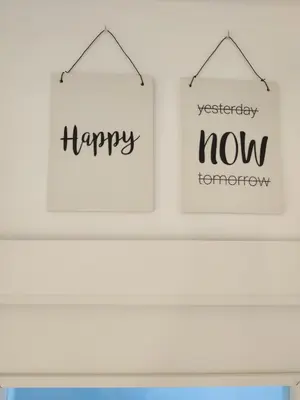 two signs that say happy and happy now on a shelf at SHERRY HOME in Jerez de la Frontera