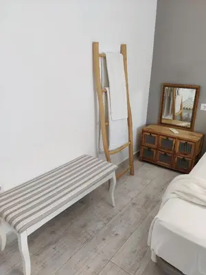 a room with a bench and a mirror and a dresser at SHERRY HOME in Jerez de la Frontera