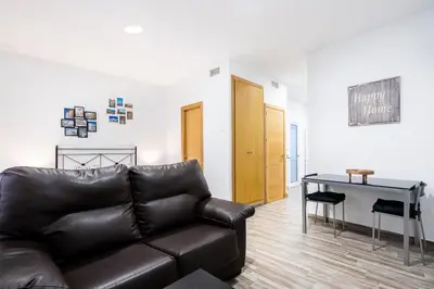 a living room with a leather couch and a table at Encantador loft Teatro Falla in Cádiz
