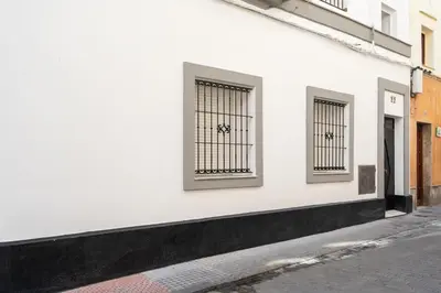 a white building with two windows on a street at Encantador loft Teatro Falla in Cádiz