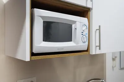 a microwave in a cabinet in a kitchen at Encantador loft Teatro Falla in Cádiz