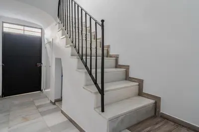 a staircase in a house with a black door at Encantador loft Teatro Falla in Cádiz