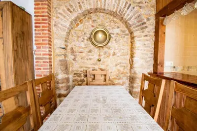 a dining room with a table and a brick wall at Casa Rural Napoleón in Medina Sidonia