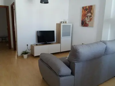 a living room with a couch and a television at Ático en el centro con terraza in Cádiz