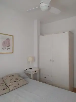 a bedroom with a bed and a white cabinet at Ático en el centro con terraza in Cádiz