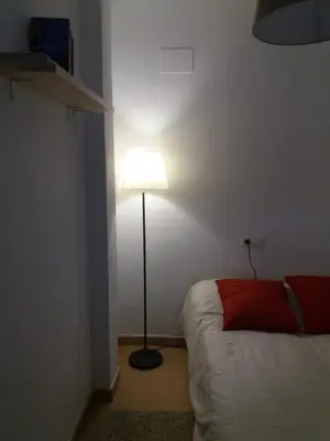 a bedroom with a lamp next to a bed at Ático en el centro con terraza in Cádiz