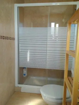 a bathroom with a toilet and a window with blinds at Ático en el centro con terraza in Cádiz