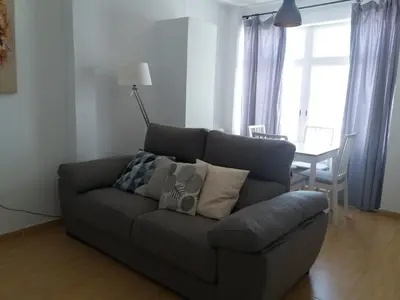 a gray couch in a living room with a table at Ático en el centro con terraza in Cádiz